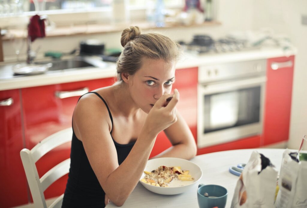 girl eating oatmeal with protein and how to add protein to oatmeal