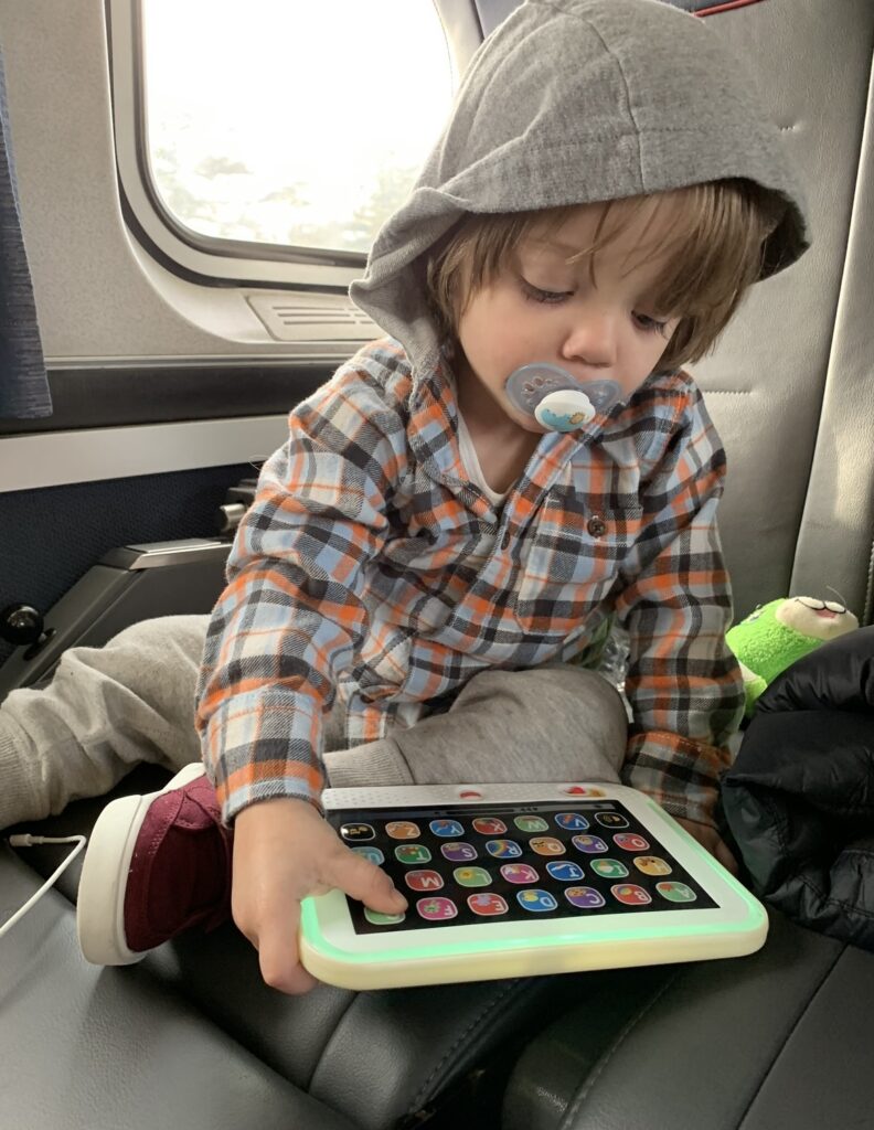 travel hack, kid playing with ipad on airplane