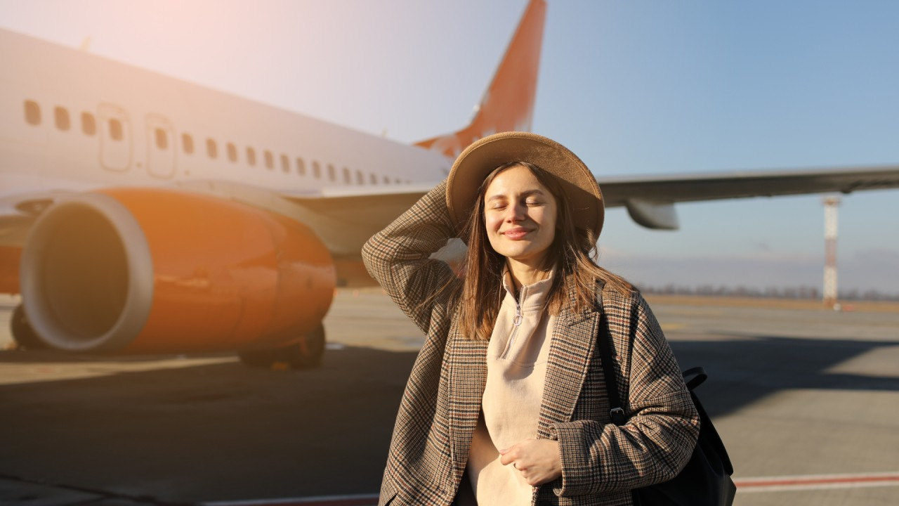 girl smiling on plane packing list for long flights