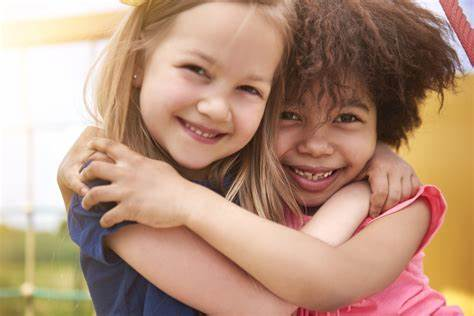 two diverse kids hugging